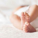 Court’s Stunning Sentence Hike for Baby Killer Close-up of baby feet lying on blanket.