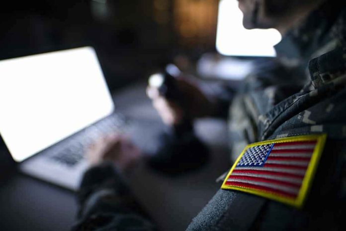 1395036650 Soldier using laptop with US flag patch visible.