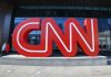 Large red CNN sign outside building entrance.