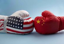 China’s Chokehold Strangles U.S. Defense USA and China boxing gloves facing each other.