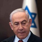 Trump and Netanyahu No Longer Aligned Man in suit with Israeli flag in background.