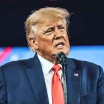 TRUMP’S SNAP SHOCKER: Aid Withheld from Key States Man in suit speaking at a microphone.