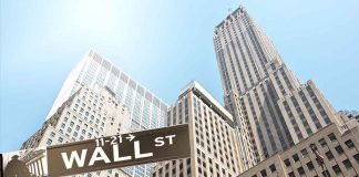 Street signs for Wall Street and Broad Street with skyscrapers in the background