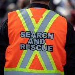 Daring Rescue: Quicksand Swallows Hiker Whole Person wearing a bright orange search and rescue vest