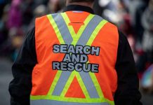 Alligator-Infested Swamp Traps Barefoot Adventurers Person wearing a bright orange search and rescue vest