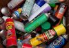 A pile of discarded spray cans in a garbage bin