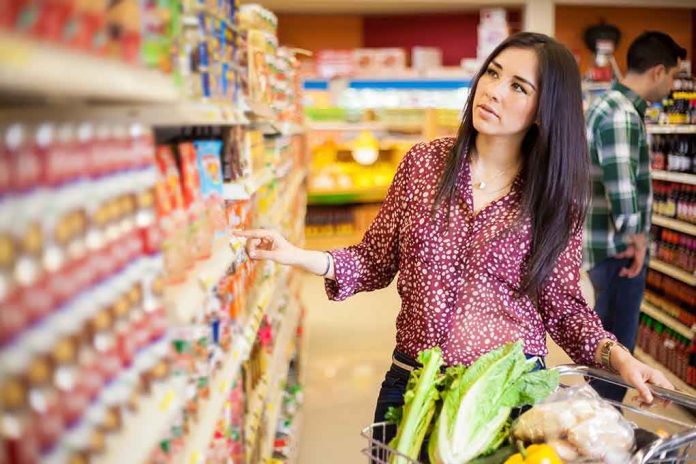 shutterstock_182011403.jpg Woman shopping in a grocery store aisle with a cart full of vegetables