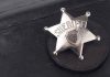 Liberal Justices Target Sheriffs—ICE Cooperation at Risk A silver sheriff badge resting on a black leather surface