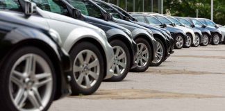 A row of parked black and silver cars in a dealership