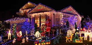 A house decorated with colorful Christmas lights and festive figures