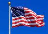 Democrat’s SHOCKING ‘Great Satan’ Claim Stirs Chaos Waving American flag against a clear blue sky
