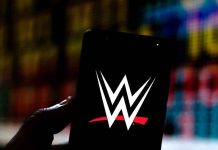Hand holding phone displaying WWE logo.