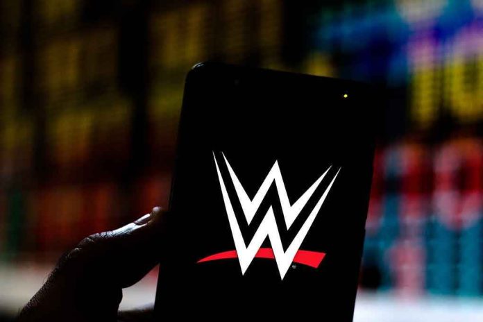 1468845056 Hand holding phone displaying WWE logo.