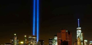 New York City skyline at night with memorial lights.