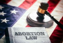 Abortion law book, gavel, and American flag.