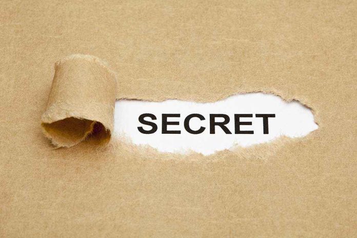 shutterstock_147112922.jpg A torn piece of brown paper revealing the word SECRET underneath