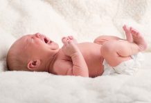 Georgia Baby FIGHTS For Life! A newborn baby lying on a soft blanket, crying with a distressed expression