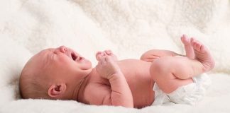 Georgia Baby FIGHTS For Life! A newborn baby lying on a soft blanket, crying with a distressed expression