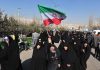Iran’s $7 Dollar Price Tag Group of women in black attire marching with an Iranian flag