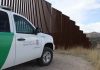 Egyptian Rapist Slips Through Biden Borders Border protection vehicle near a large metal fence.