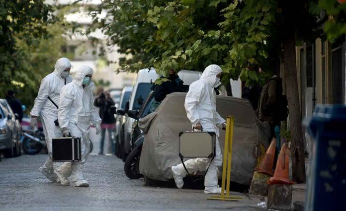 Investigators in hazmat suits carrying equipment cases.