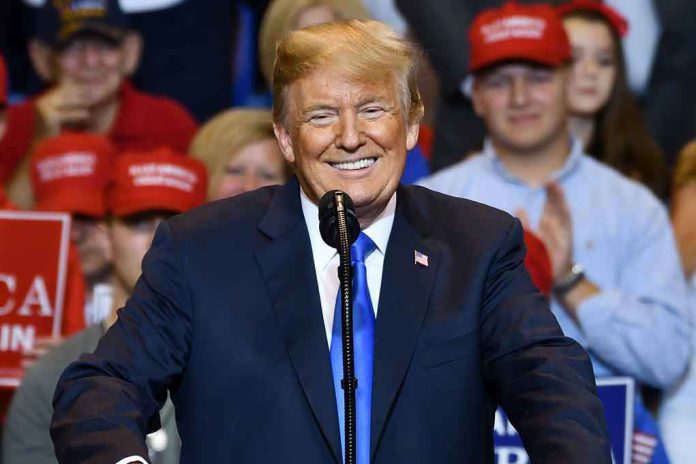 Man in suit speaking at rally with red hats.