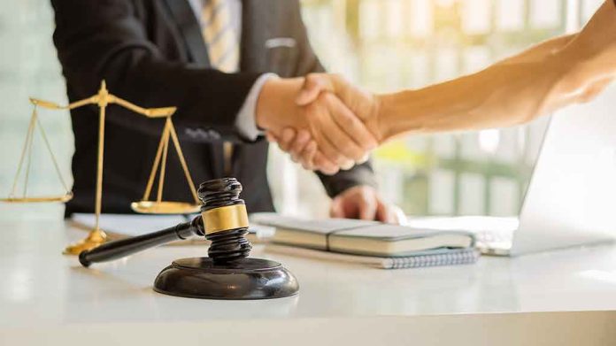 Hands shaking over legal documents with gavel and scales.