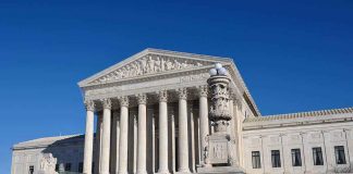 The Supreme Court building with large columns and a clear blue sky