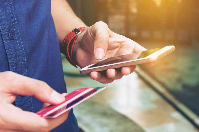 Person holding a smartphone and a credit card, preparing for a digital transaction
