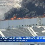 Local emergency declared as Boyle Heights warehouse fire flare-ups persist, smoke drifts beyond area