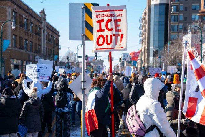 shutterstock_2718210697 Crowd of protesters holding signs at a rally against ICE