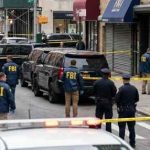 FBI agents and police officers at a crime scene with police tape