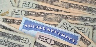 A social security card placed among various denominations of US currency