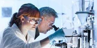 Scientists working in a laboratory with protective goggles and gloves