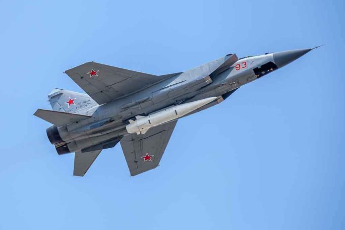 fighter jet with missile flying against a clear blue sky