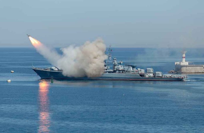 shutterstock_533229181 Warship launching a missile at sea