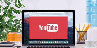 YouTube logo on a laptop screen on desk.