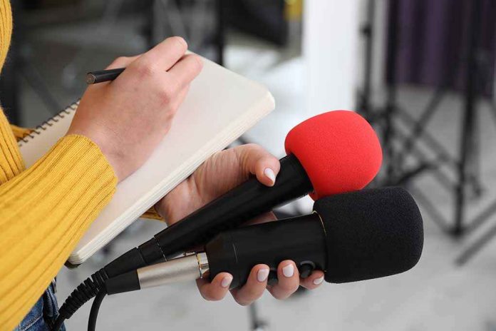 default-hero-05-1 Journalist holding two microphones while writing in a notebook