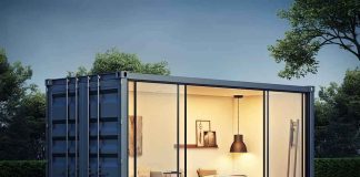 shipping container home with glass walls at dusk
