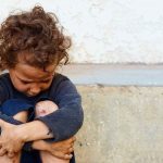 16 Kids Found — Systems Failed Everywhere child sitting on ground with arms wrapped around knees