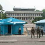Zelensky Revealed Something South Korea Wanted Secret Military personnel standing near blue buildings at a border crossing