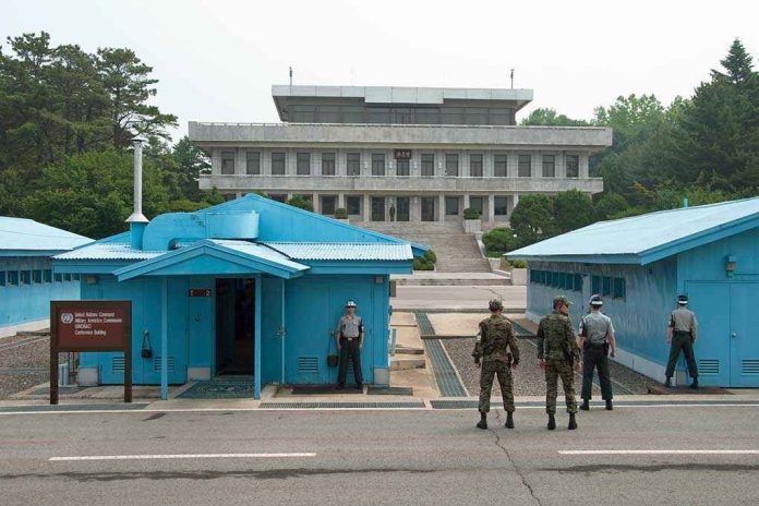 Military personnel standing near blue buildings at a border crossing
