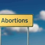 California Signs 4 New Abortion Access Laws Yellow road sign with the word abortions against a blue sky