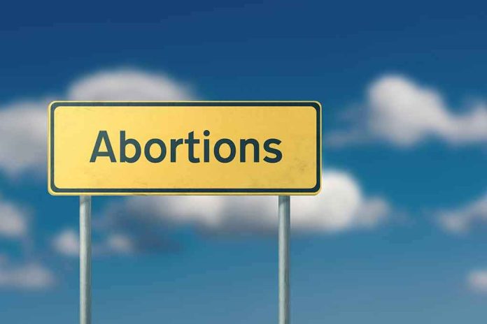 shutterstock_1136640221 Yellow road sign with the word abortions against a blue sky