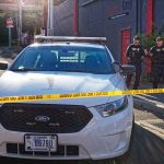 Police car behind yellow caution tape on a city street