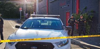 Police car behind yellow caution tape on a city street