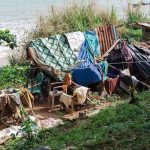 Pacific Islands Face Food Shortages makeshift shelter near a beach with tarps and clothes drying