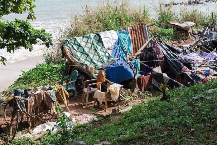 shutterstock_1227905014 makeshift shelter near a beach with tarps and clothes drying