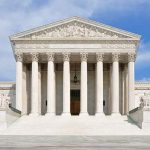 Supreme Court Showdown Over No-Bond Detentions Front view of the Supreme Court building with large columns and steps under a blue sky