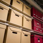 Shelves filled with brown and red storage boxes for organizing documents